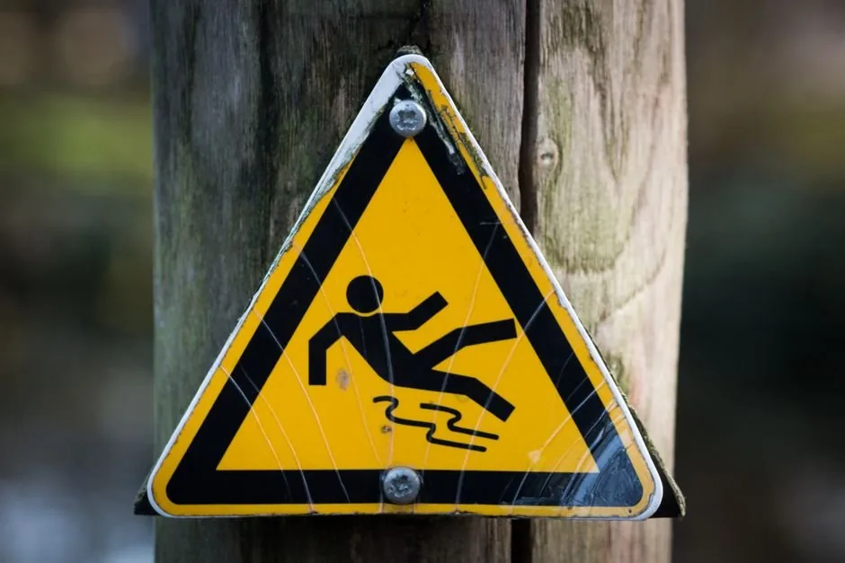 Warning sign on a wooden post